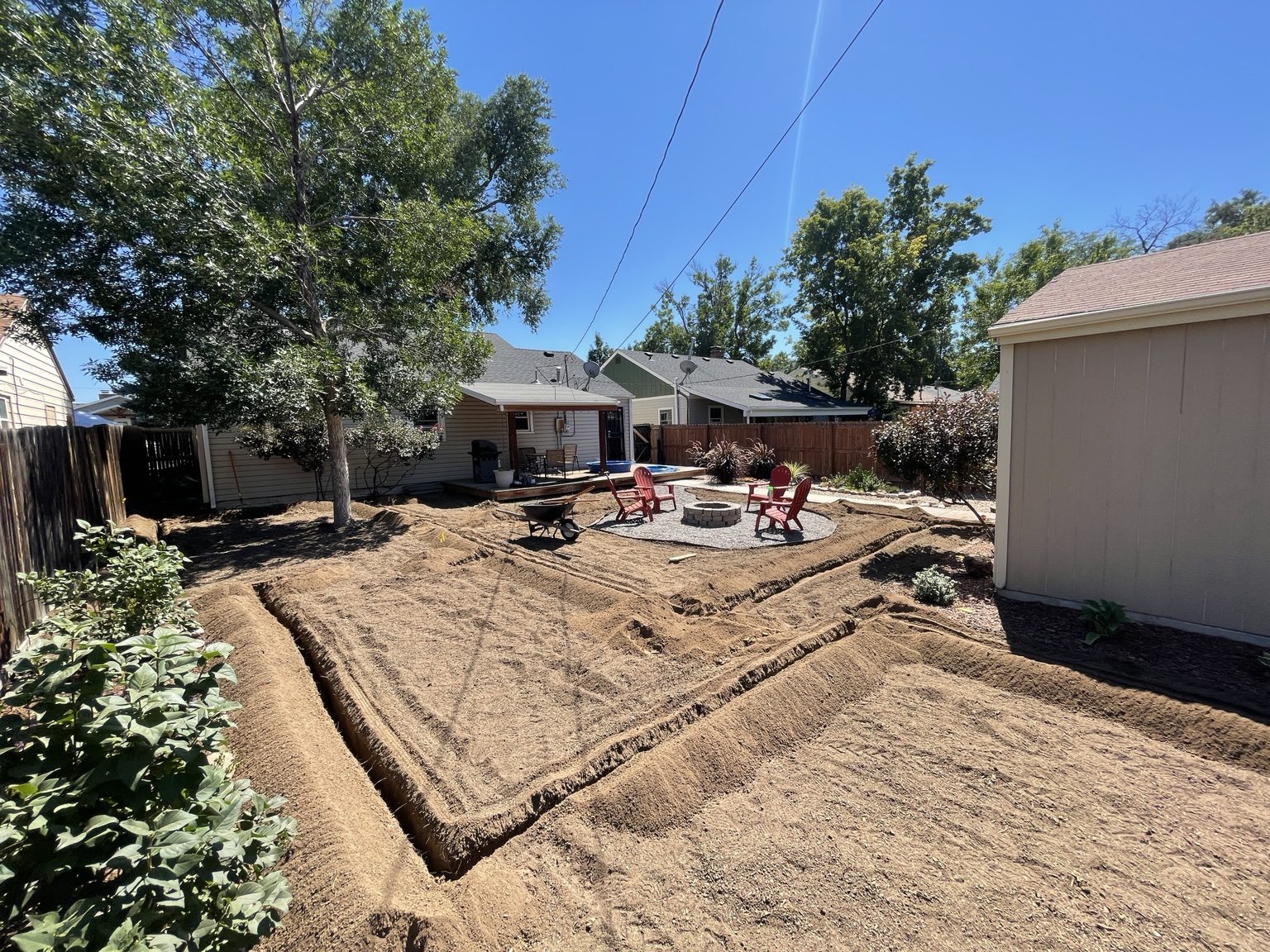 Open irrigation trenches laid out across the backyard before piping and backfill